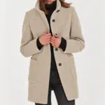 Isabella damesjas met hoge kraag in beige, gedragen over een zwarte coltrui