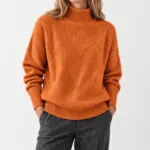 Lyselle coltrui met ruitpatroon in oranje, gedragen met een grijze pantalon