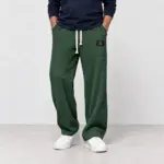 Comfortabele wafelbroek met wijde pijp in donkergroen, gedragen met witte sneakers