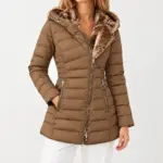 Fenna gewatteerde winterjas met capuchon in camel, gedragen met een witte broek