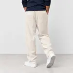 Ribbroek met rechte pijp in crème, van achteren gezien, met witte sneakers
