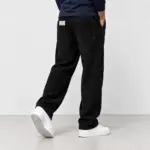 Ribbroek met rechte pijp in zwart, van achteren gezien, met witte sneakers